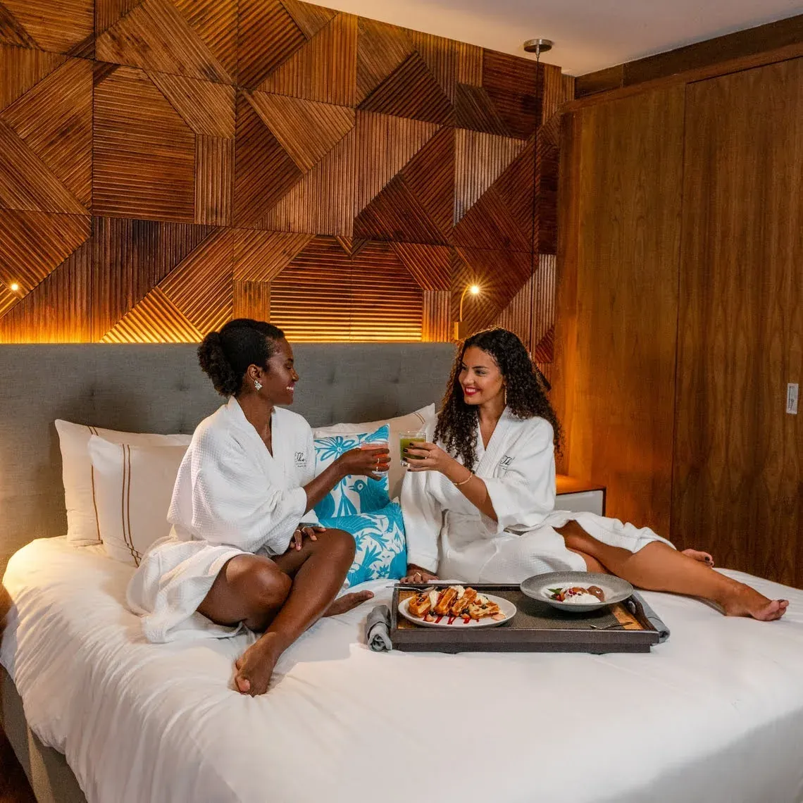 Dos mujeres brindan en The Fives Corpo con desayuno en la cama.