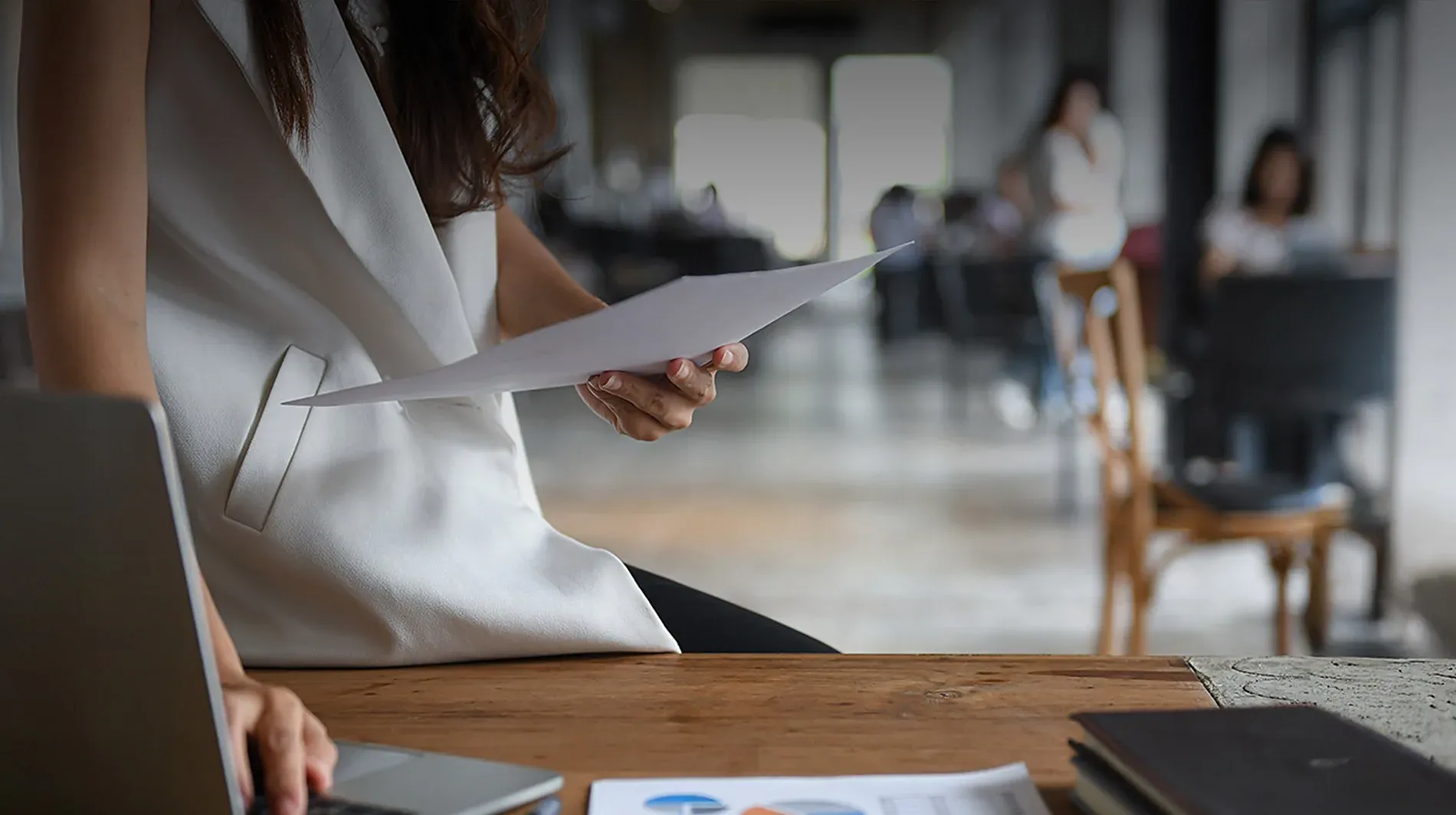 Mujer revisando documentos en oficina moderna. Empleos en The Fives Hotels & Residences México.