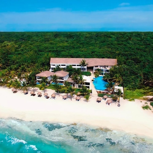an aerial view of a beach resort surrounded by palm trees