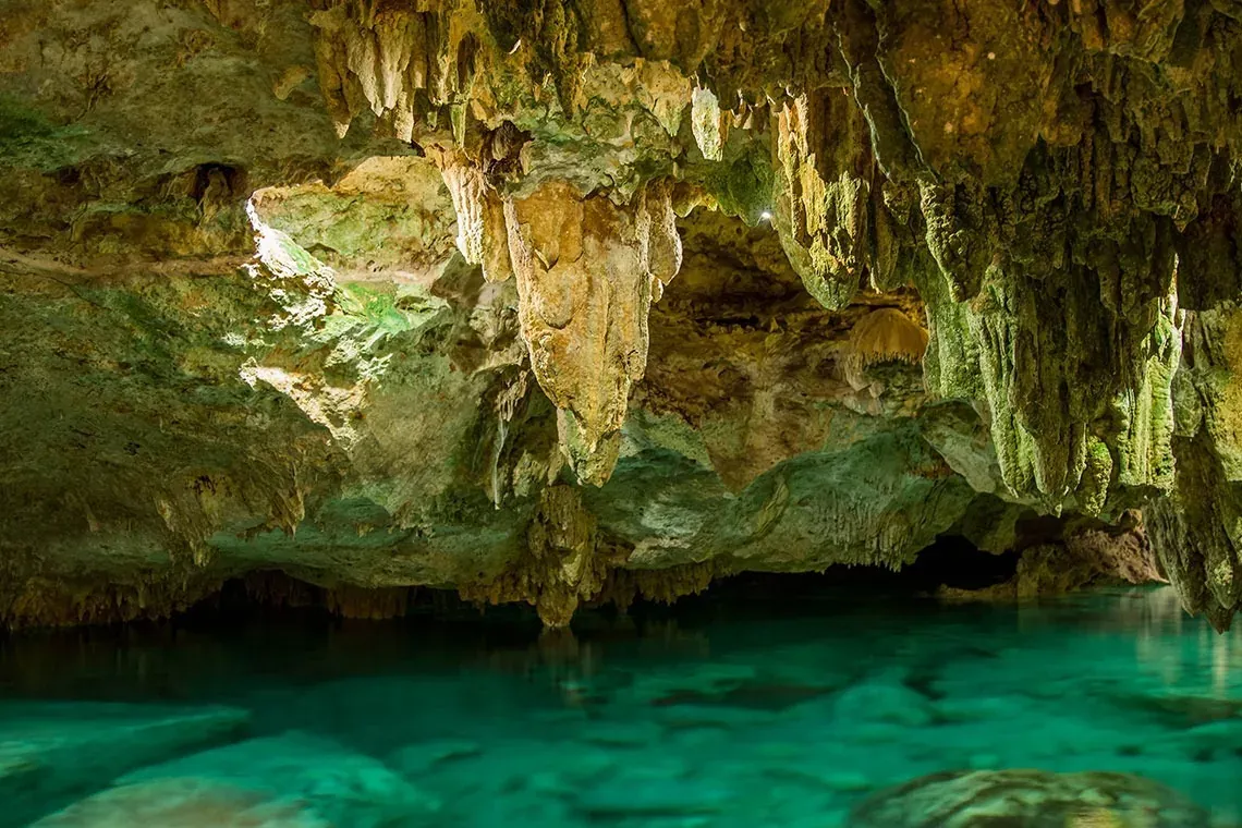 Descubre The Fives Corpo: cenote místico con agua turquesa y formaciones rocosas.