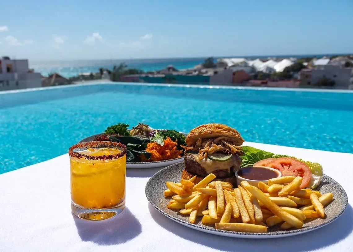 Disfruta de una hamburguesa y cóctel junto a la piscina en The Fives Downtown Hotel - Curio Collection by Hilton | México | Web oficial.