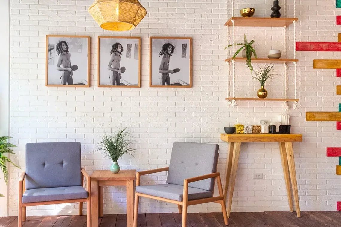 Cozy corner at The Fives Corpo with chairs, table, and wall art.