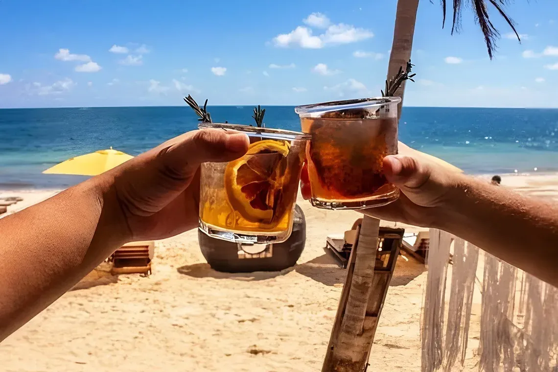 Brindis en The Fives Corpo: cócteles en la playa, mar azul, palmeras y relax total.