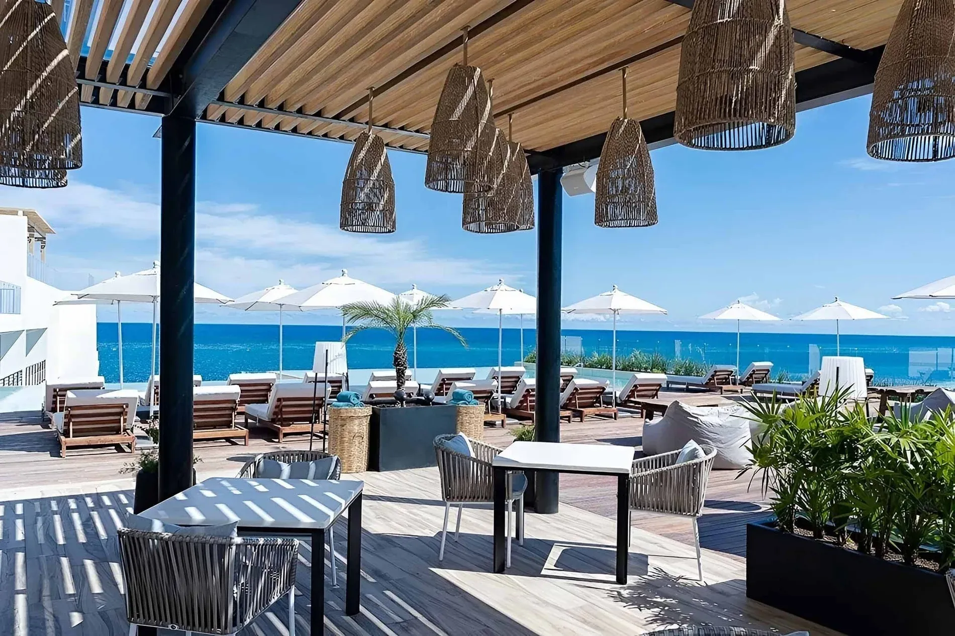 The Fives Corpus Christi: Oceanfront terrace with tables, chairs, and loungers.