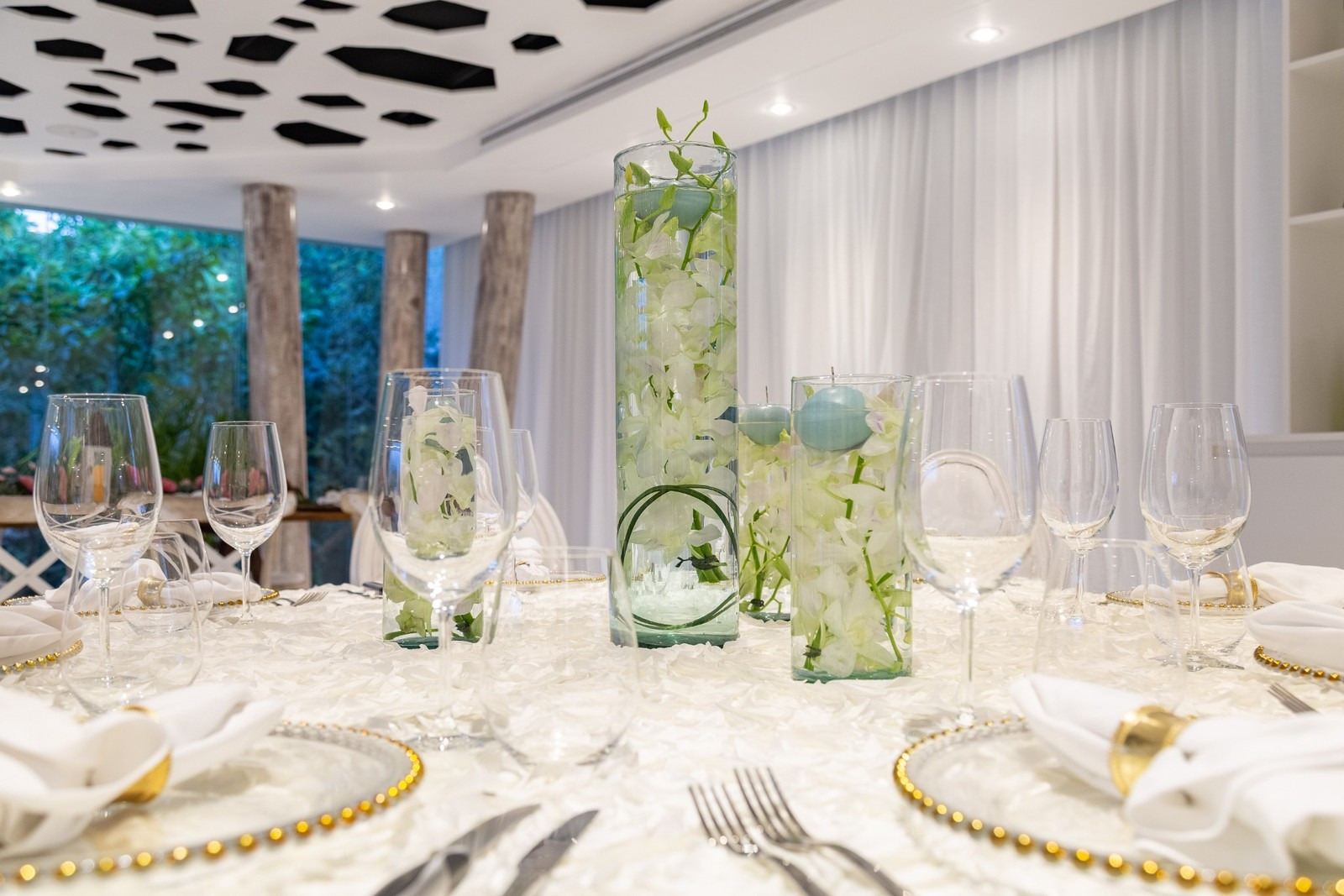 Montaje de boda en lugar interior con mesas elegantes y detalles florales en el Caribe Mexicano