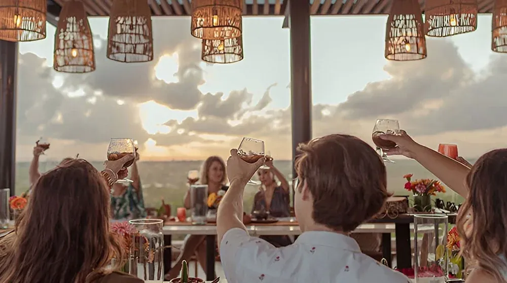 Toast to luxury at The Fives Corpo, enjoying sunset views.