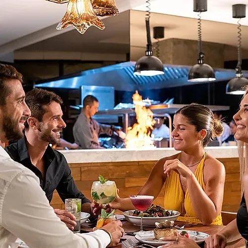 Couple enjoying romantic dinner at The Fives Corpo, with open kitchen.