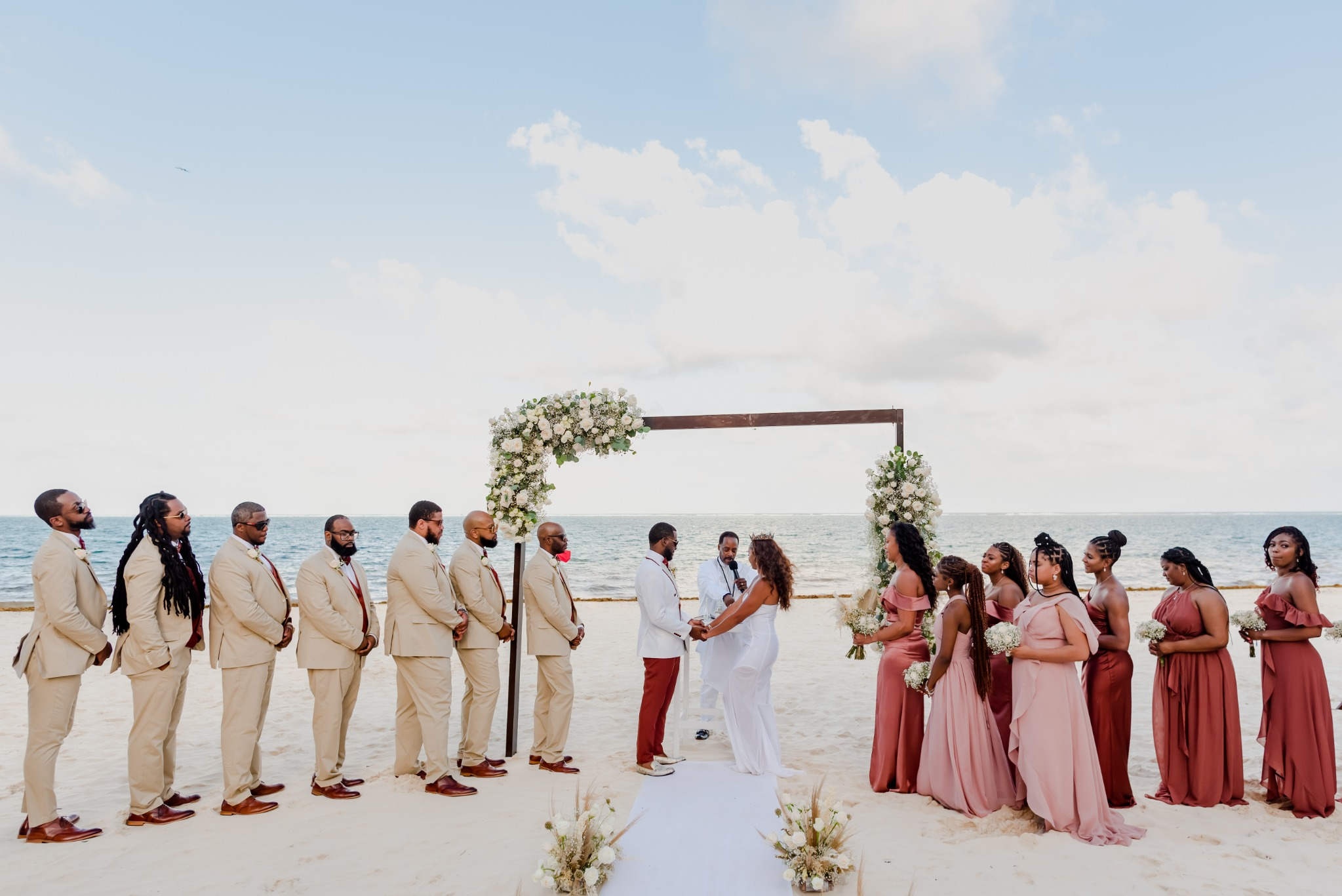 Sunset beach wedding ceremony in Riviera Maya with floral decor