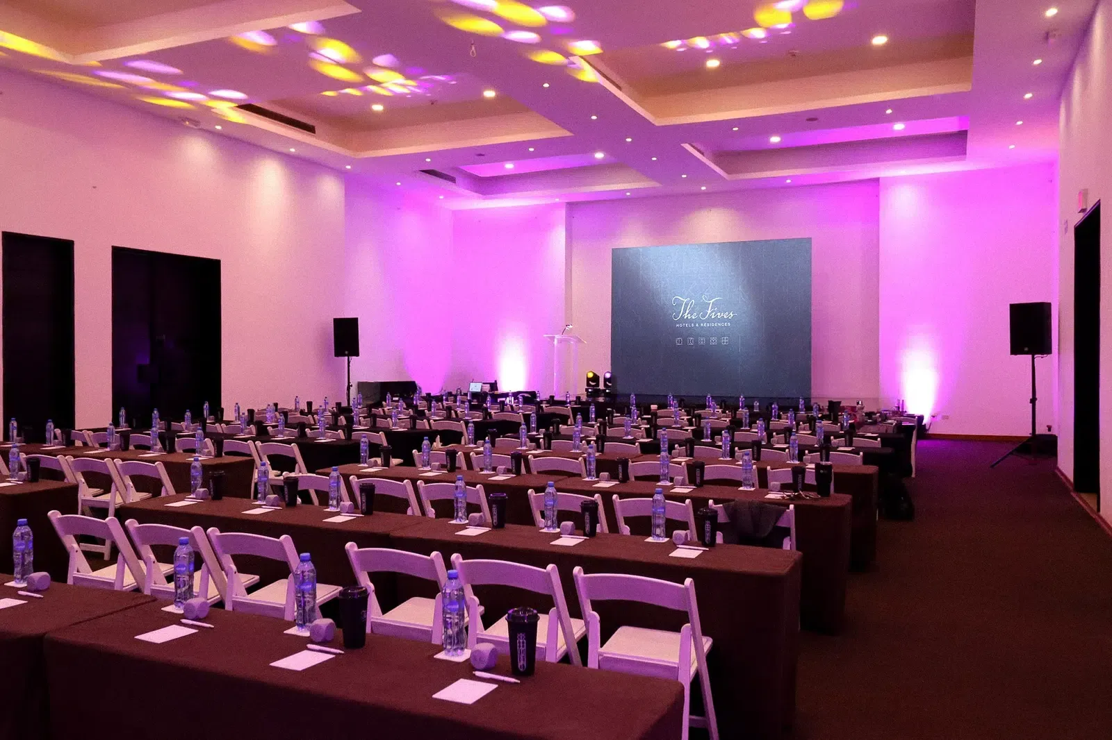 Conference room setup at The Fives Hotels The Fives Corpo, with projector screen and seating.