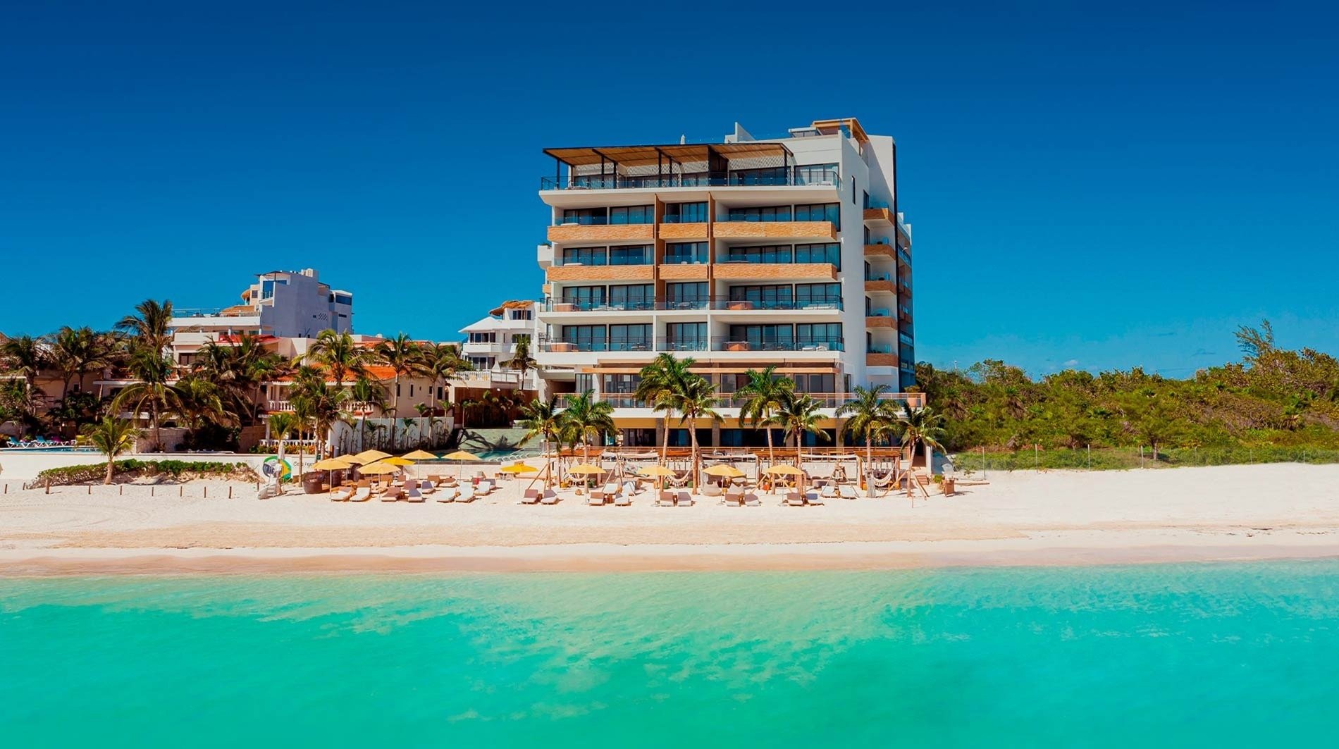 un gran edificio blanco y marrón se encuentra en la playa