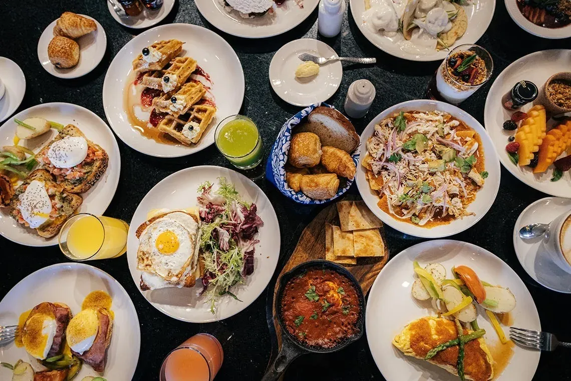 Desayuno gourmet en The Fives Corpo: waffles, huevos, frutas y más.