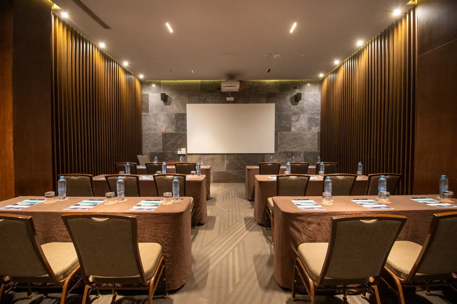 The Fives Corpo: Modern conference room with tables, chairs, and projector.