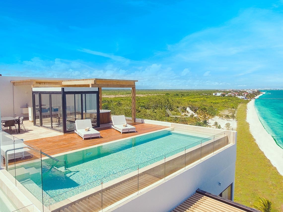 Terraza de hotel de lujo en The Fives Oceanfront Riviera Maya con piscina privada y vistas al mar Caribe.