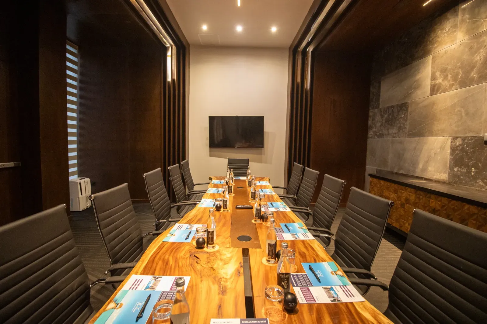 Luxury hotel The Fives Corpo: a modern boardroom with a live-edge table and plush seating.