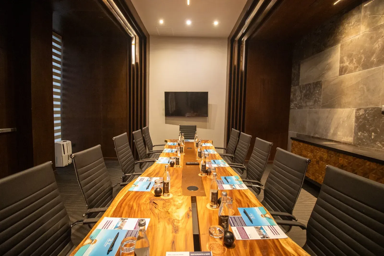 Luxury hotel The Fives Corpo: a modern boardroom with a live-edge table and plush seating.