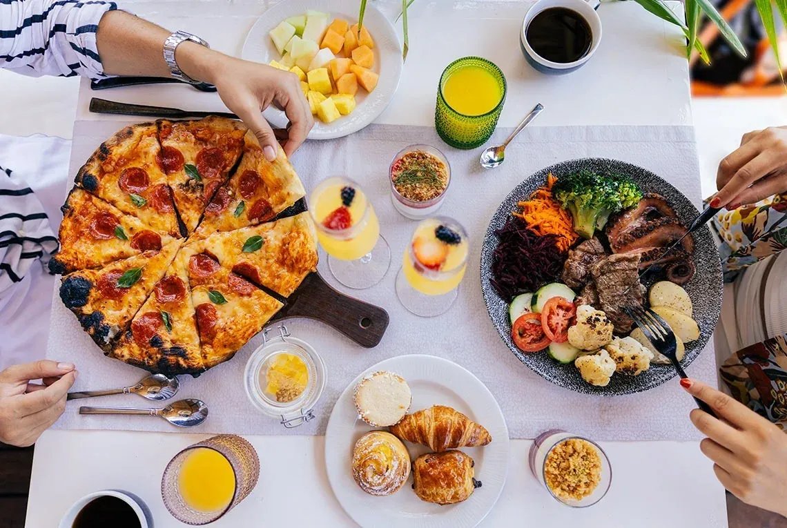 The Fives Corpo buffet spread: pizza, seafood, fruits, and pastries for a perfect start.