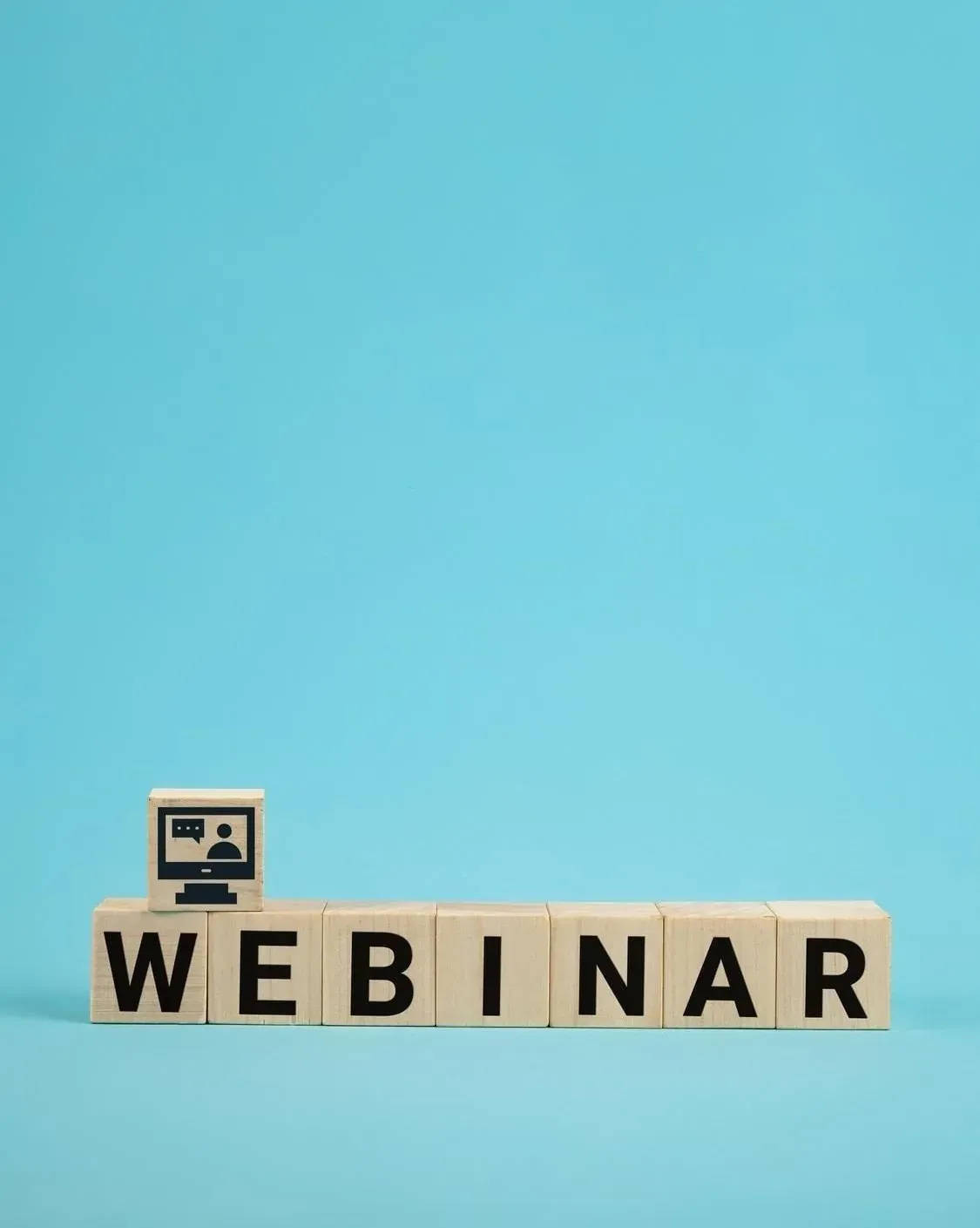 Bloques de madera con "Webinar" y un ícono de computadora en The Fives Corpo.