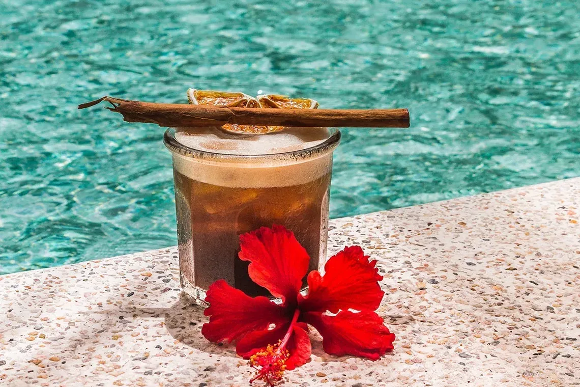 Refreshing poolside cocktail at The Fives Corpo, featuring hibiscus and cinnamon.