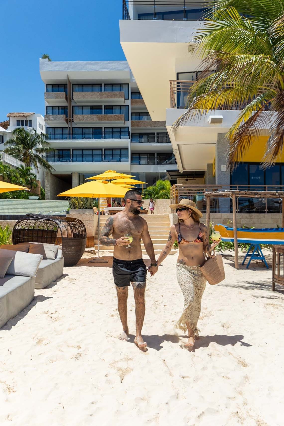 Pareja paseando en la playa de The Fives Oceanfront Riviera Maya, México.