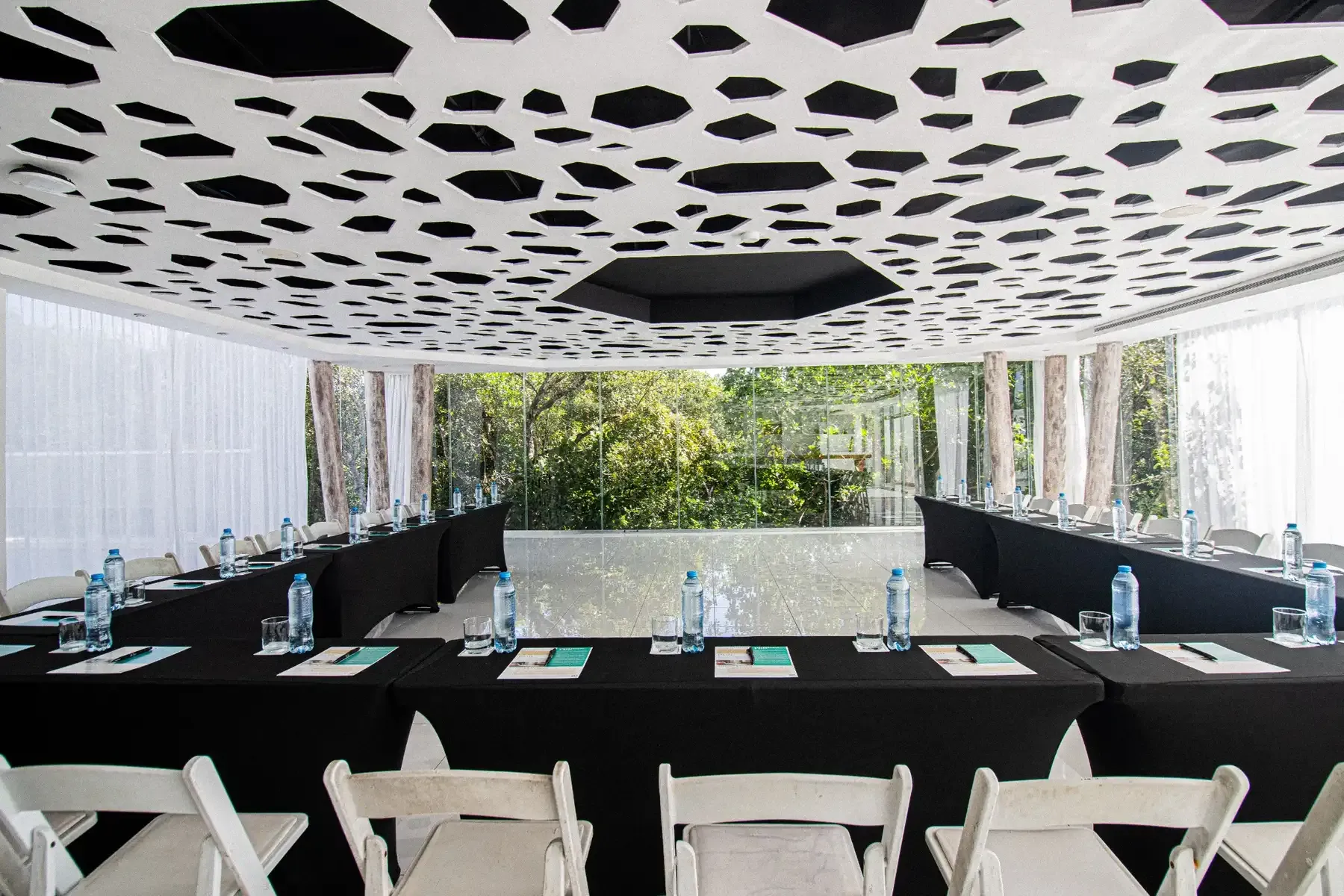Modern conference room setup with U-shaped table, water bottles, and natural light, perfect for The Fives Corpo events.