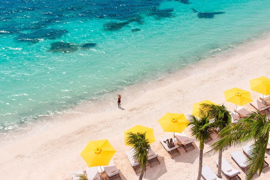 Experience paradise at The Fives Corpo: vibrant beach with crystal-clear waters.