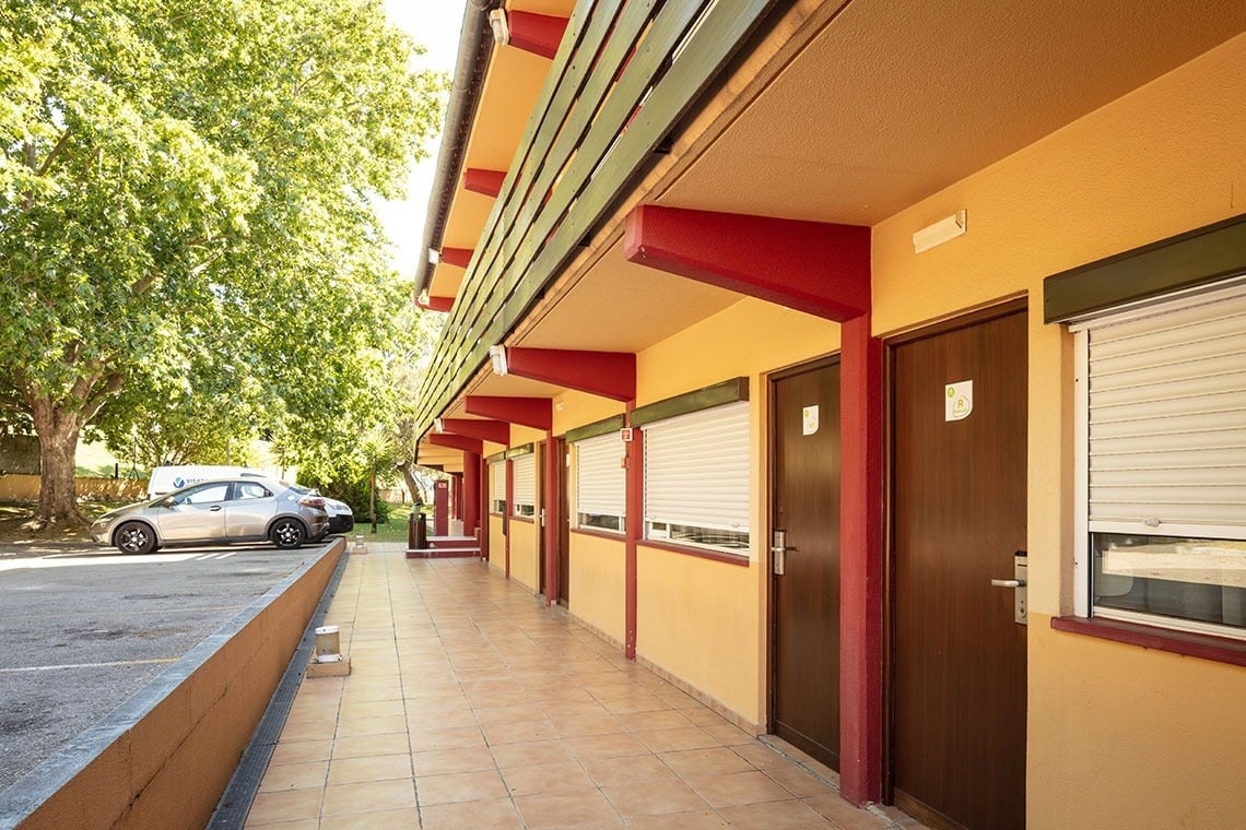 Entrada de quartos do Campanile Setúbal | Website oficial, com portas em madeira e janelas fechadas.