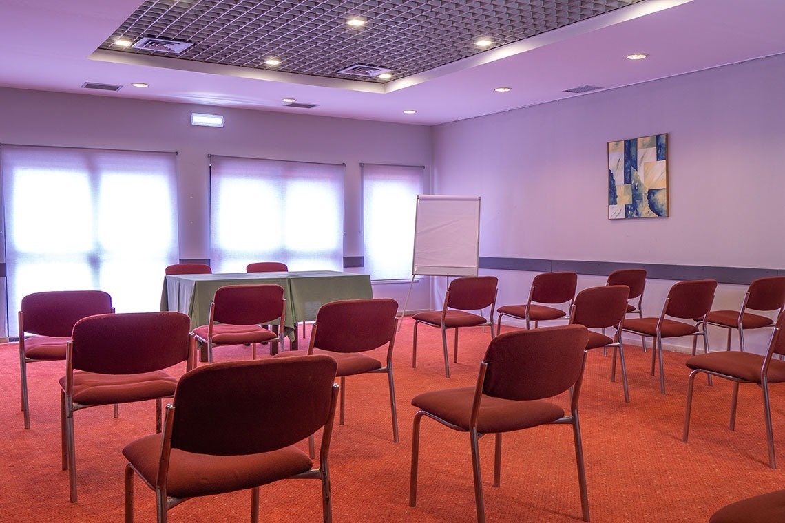 Sala de reuniones con sillas y caballete en Flag Hotel Braga.