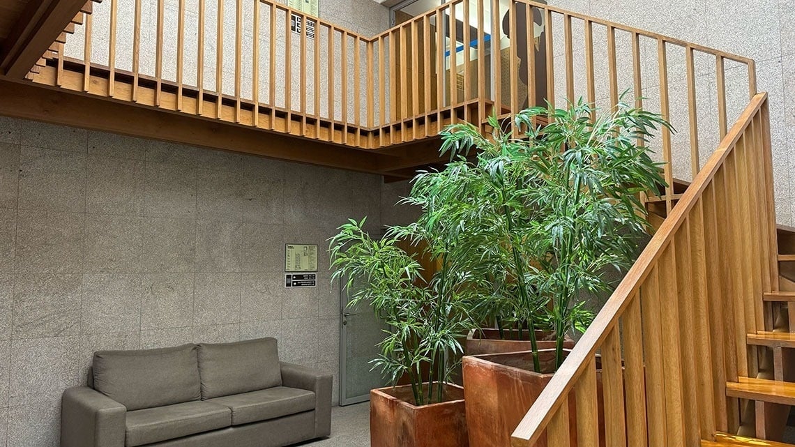 Modern lobby with couch, plants & wooden stairs | Flag Hotel Barcelos
