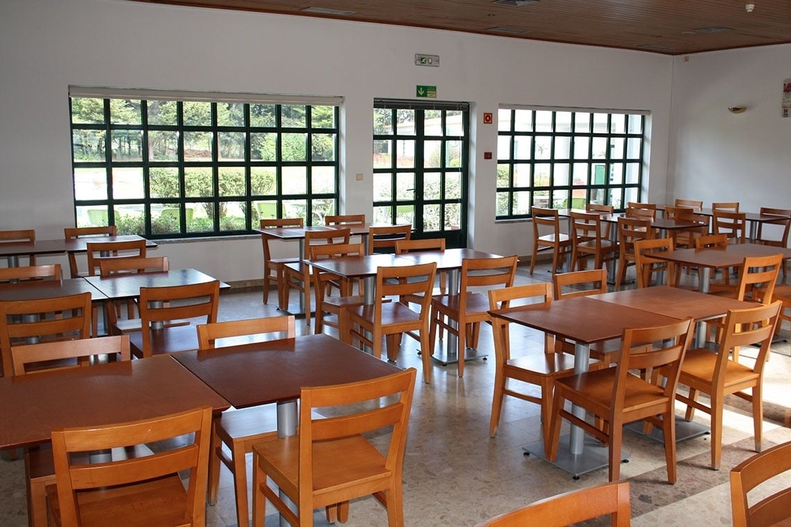 uma sala de jantar com mesas e cadeiras de madeira