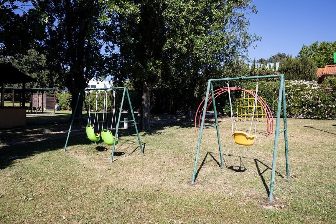 Campanile Setúbal: baloiços para crianças num jardim verdejante.