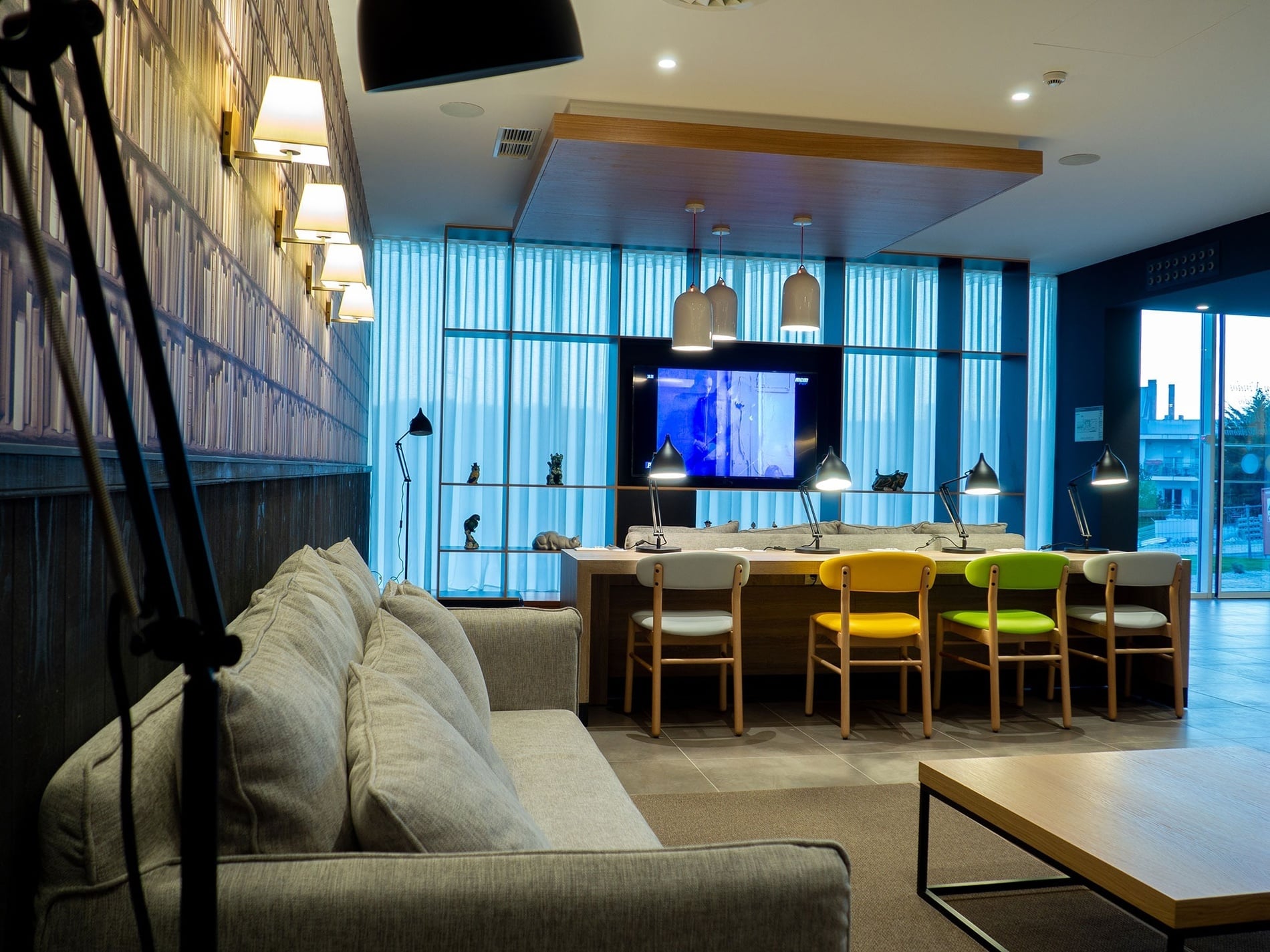 Modern hotel lounge with sofas and colorful chairs. Book at Flag Hotel Caldas da Rainha.
