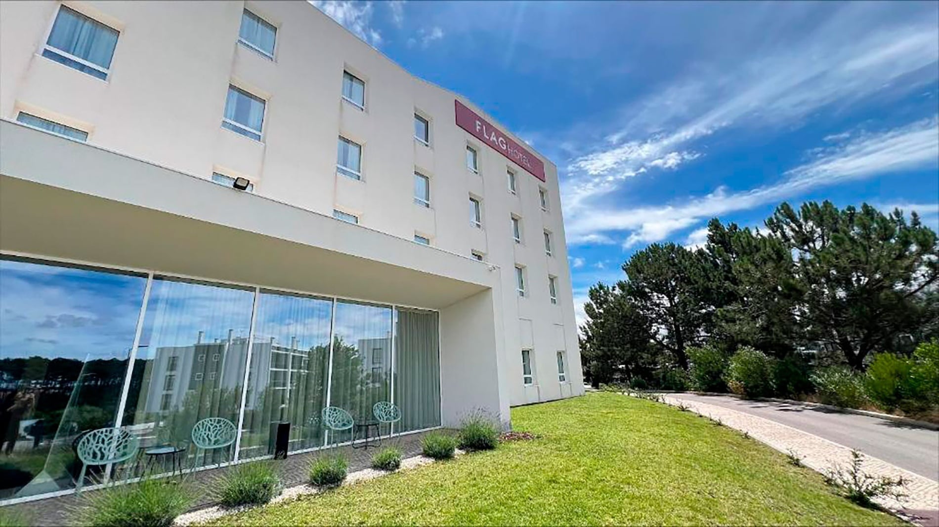 Flag Hotel Caldas da Rainha: Modern facade, glass windows, and garden.