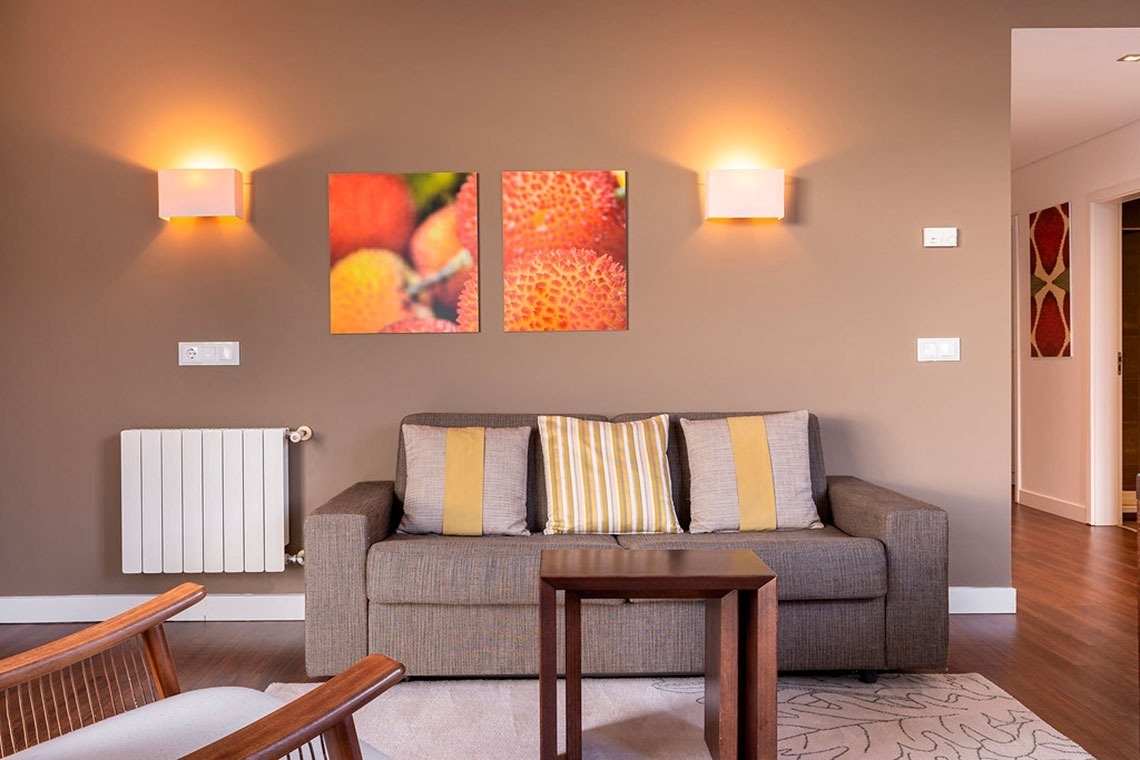 Sala de estar aconchegante no Monchique Resort & SPA by Flagworld Hotels, com arte vibrante e mobiliário confortável.