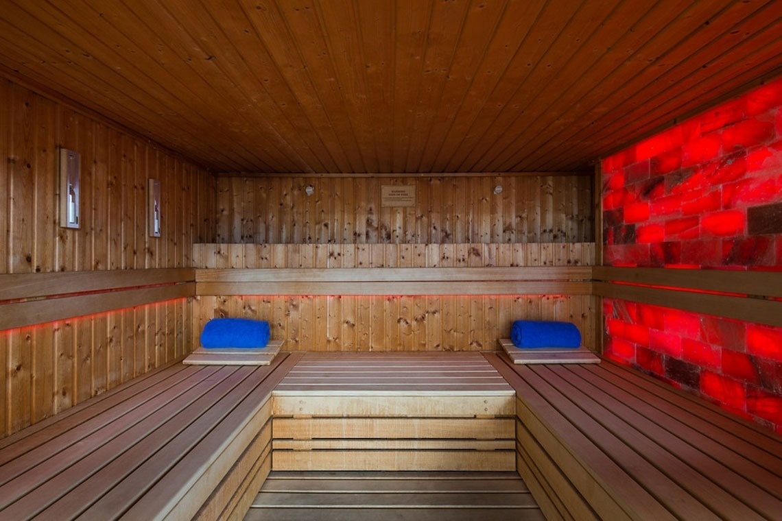 Sauna de madeira com iluminação vermelha e sais do Himalaia no Monchique Resort & SPA.
