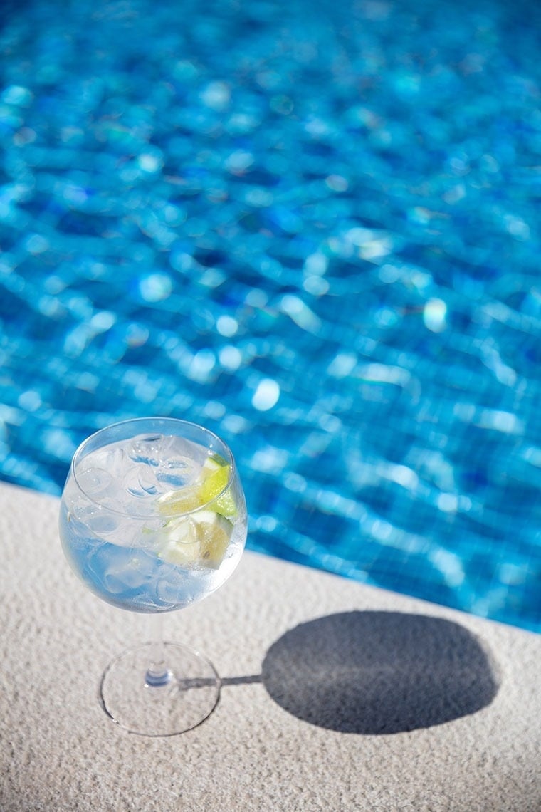 Refrescante gin tônica com limão à beira da piscina, ideal para o seu Verão no Campanile Setúbal.