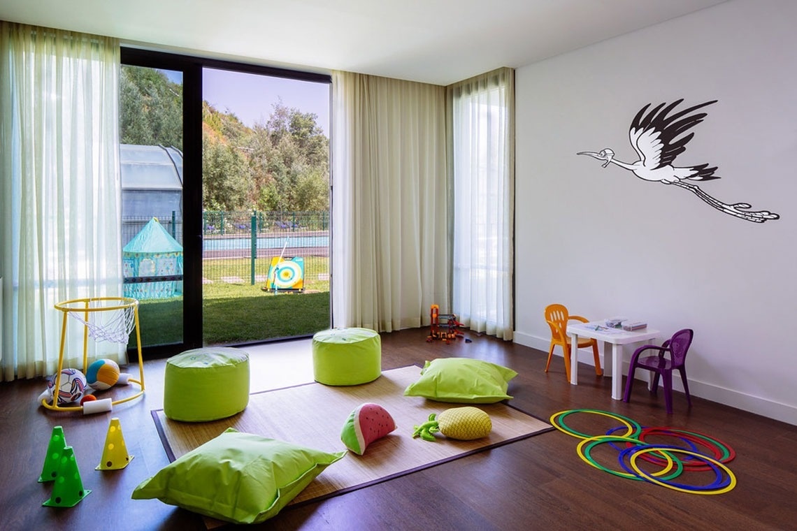 Quarto infantil no Monchique Resort & SPA com brinquedos, piscina exterior e decoração divertida.