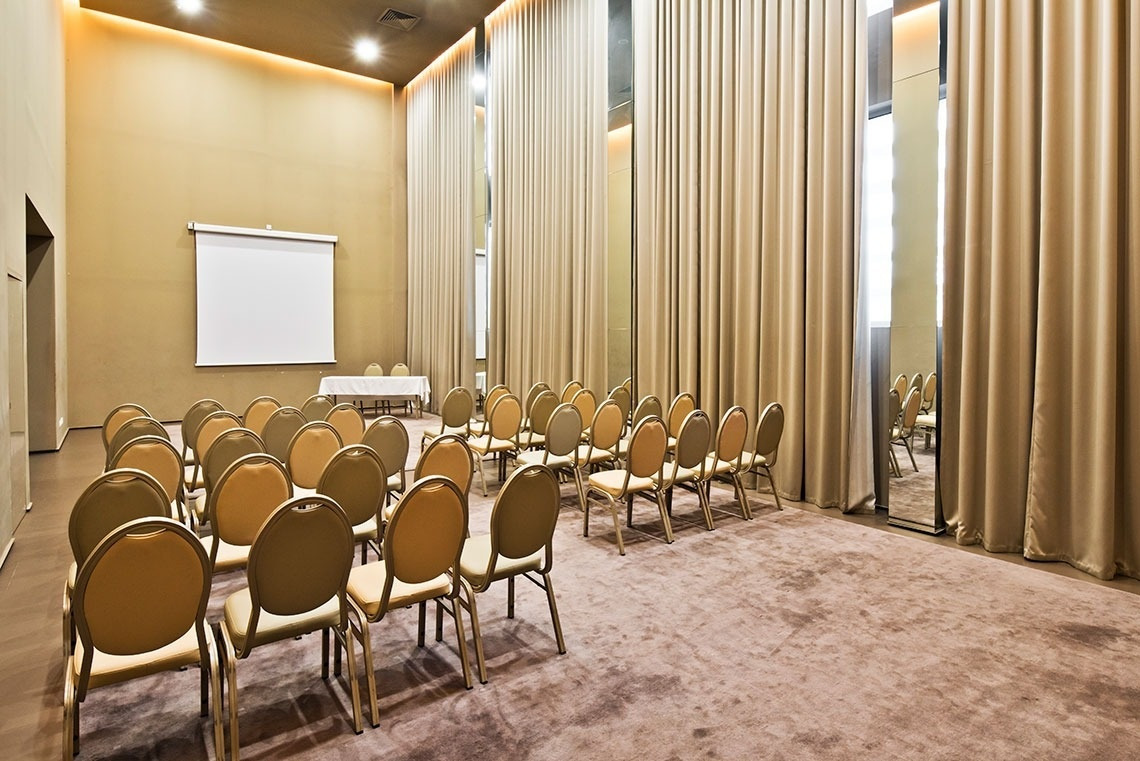 Auditorium with chairs and screen at Golden Tulip Sao Joao da Madeira | Official website.
