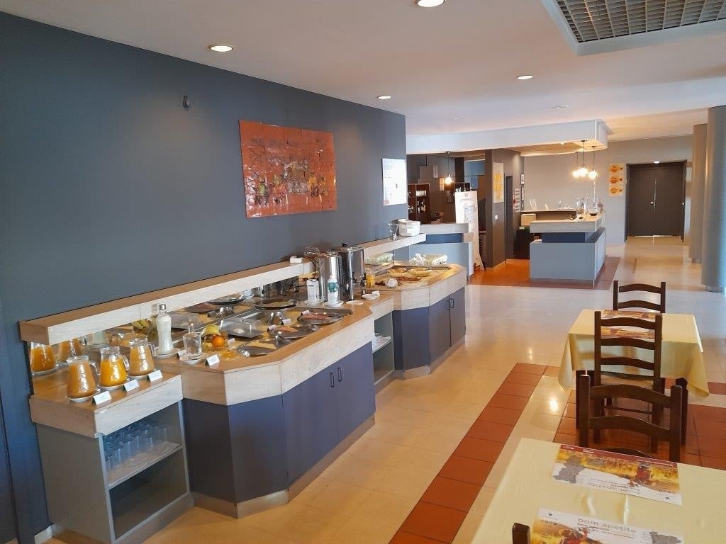 Buffet breakfast at Flag Hotel Guimarães Fafe, featuring assorted juices and food dishes.