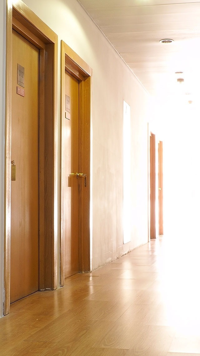 Corredor com portas de madeira em um hotel. Reserve no Flag Hotel Porto-Maia.