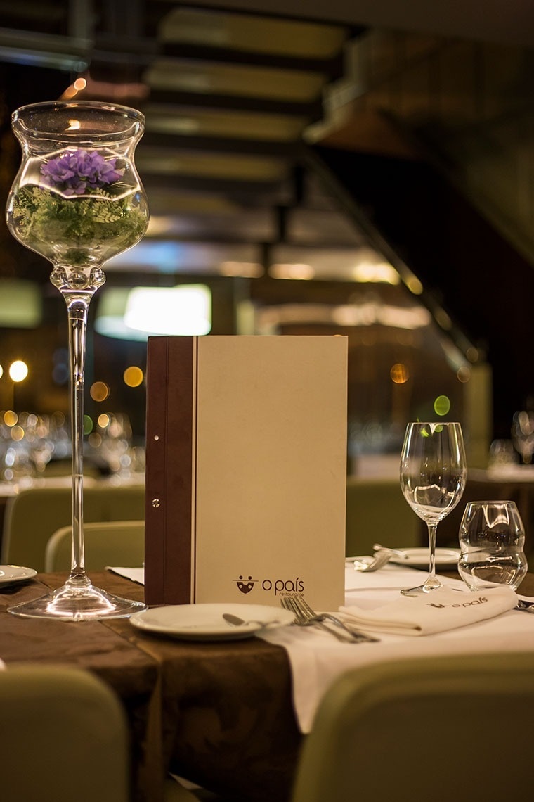 Elegant table setting at Golden Tulip Sao Joao da Madeira with floral decor and menu.