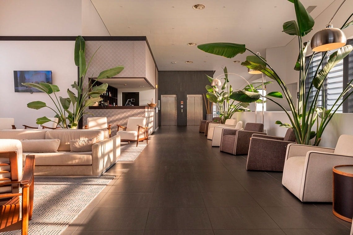 Lobby do Monchique Resort & SPA by Flagworld Hotels com sofás e plantas. Reserve já!