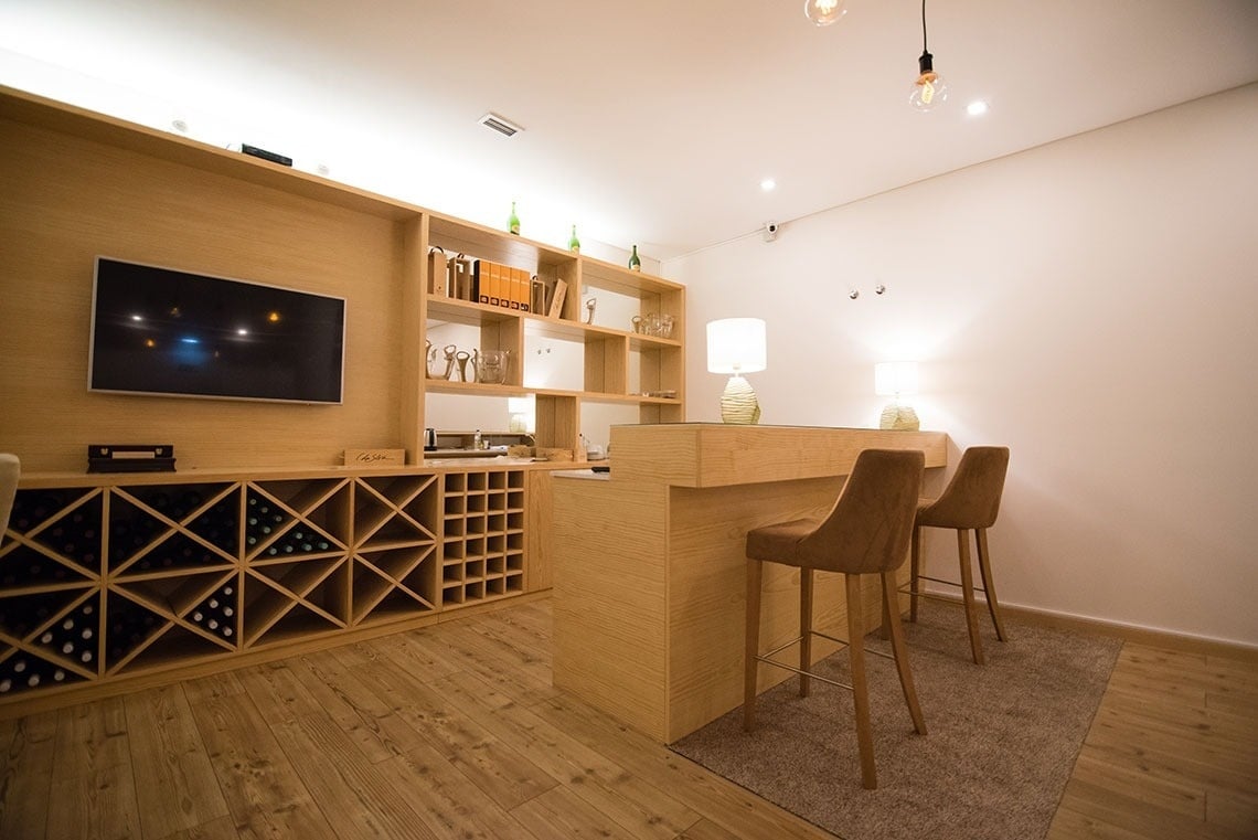 Modern bar with wine storage, featuring plush seating and elegant lamps at Lam Hotel Celorico de Basto.