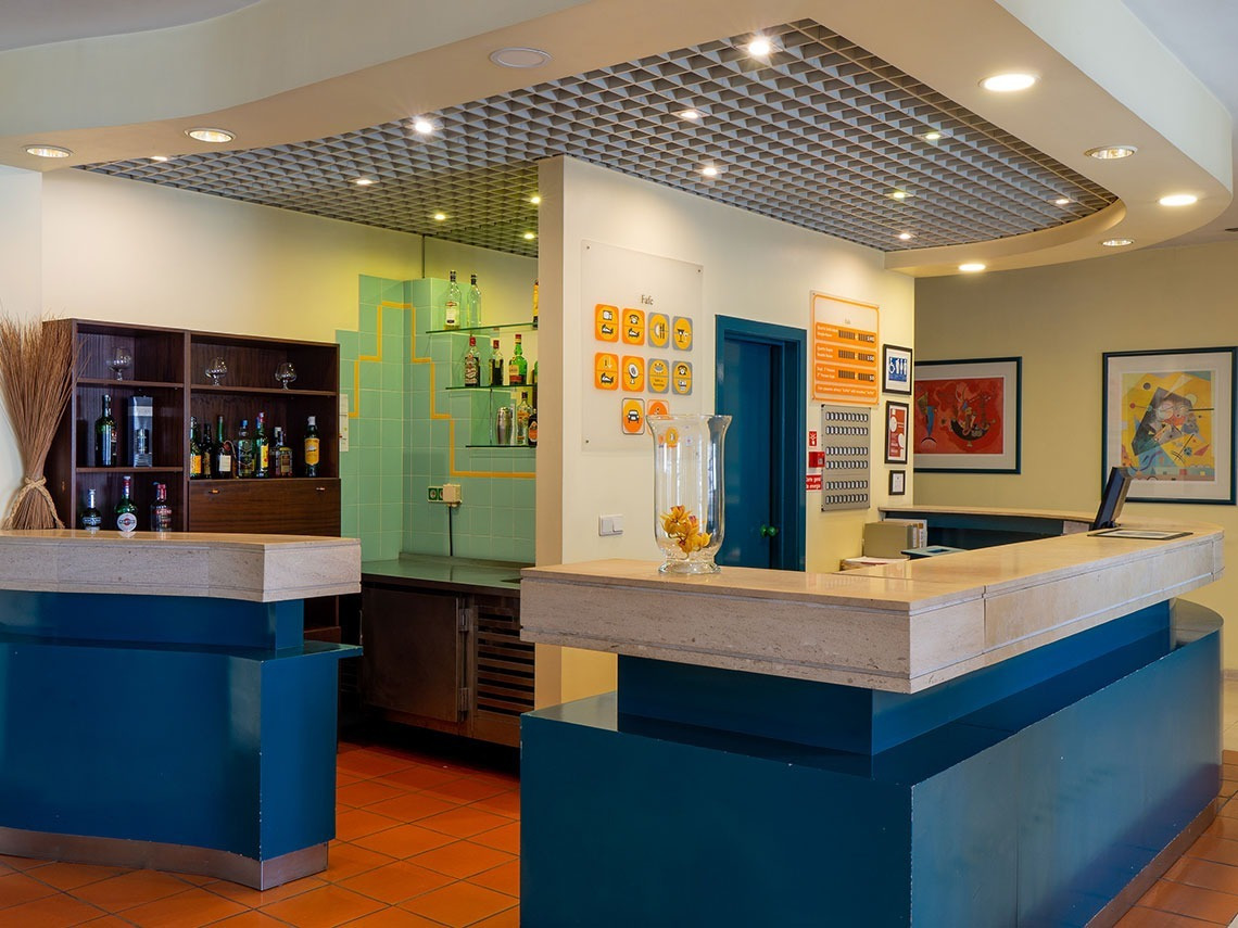 Hotel reception desk at Flag Hotel Guimarães Fafe, with modern decor and artwork.
