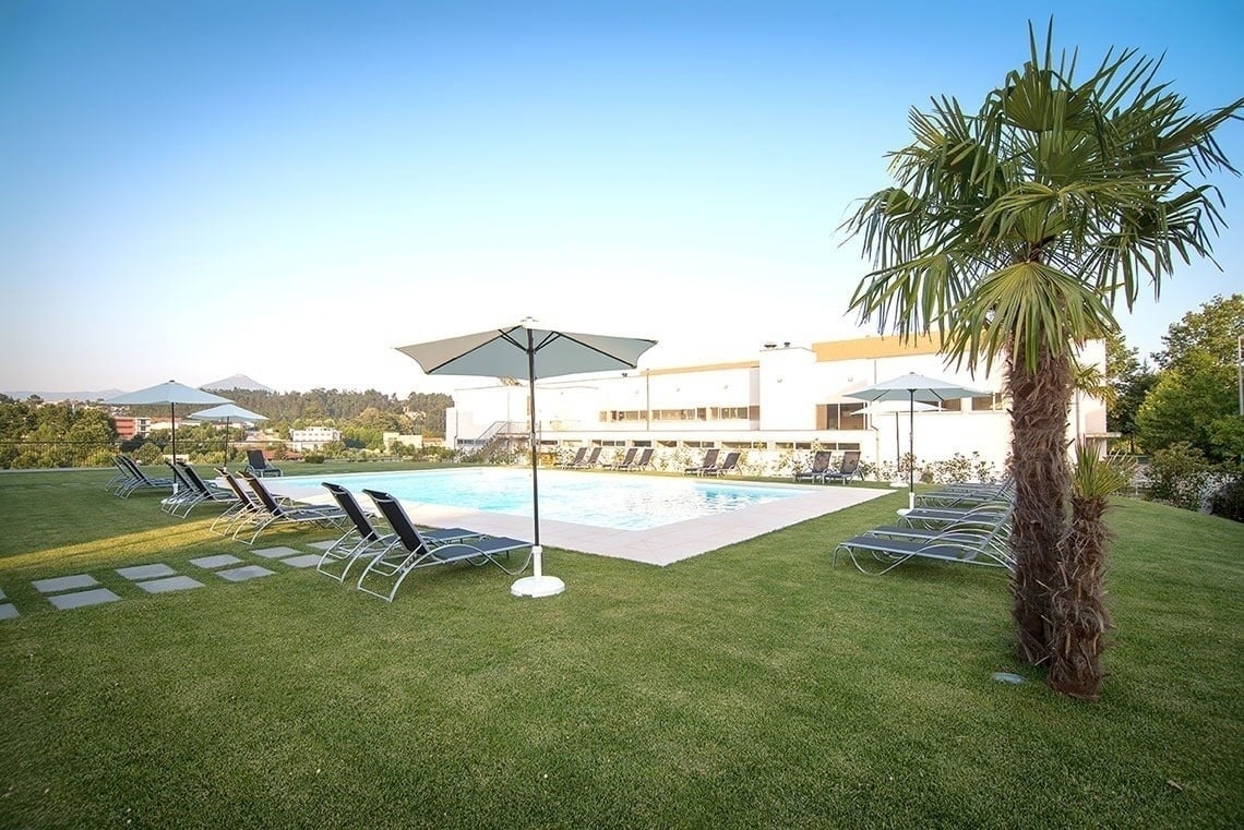 Poolside relaxation at Lam Hotel Celorico de Basto | Official website with lounge chairs & umbrellas.