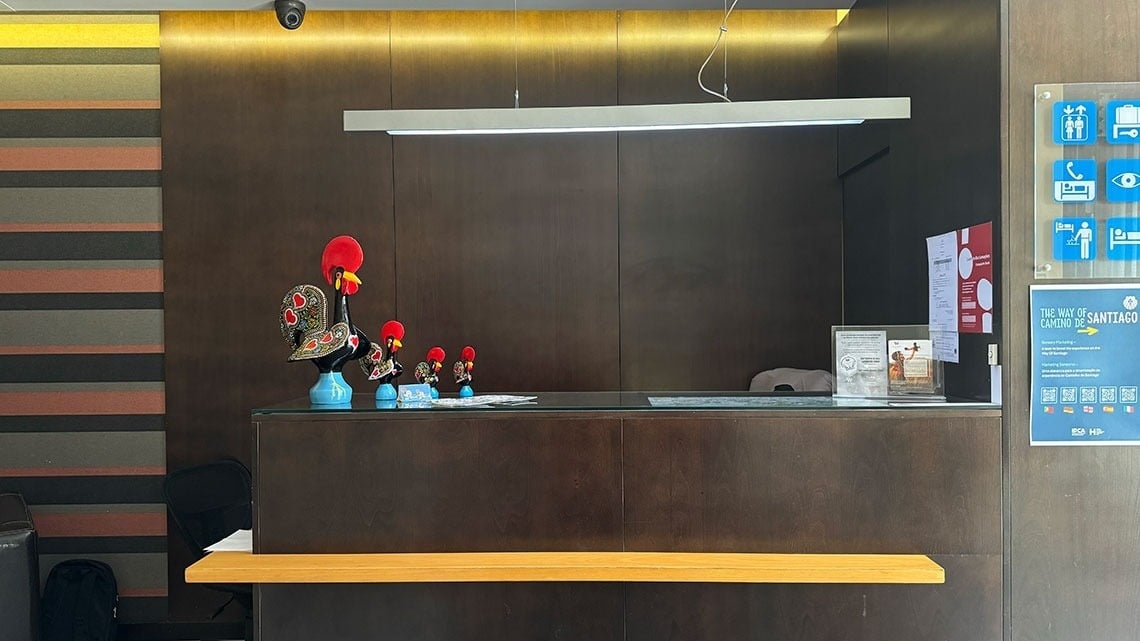 Welcome desk at Flag Hotel Barcelos, featuring decorative roosters and Camino de Santiago information. | Official Website