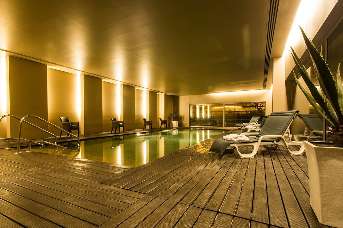 Indoor pool with loungers at Golden Tulip Sao Joao da Madeira | Official website.