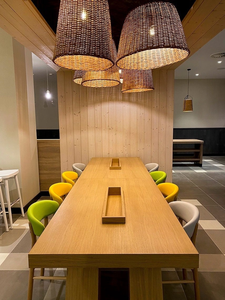 Modern dining area with wicker lamps & colorful chairs at Flag Hotel Caldas da Rainha.