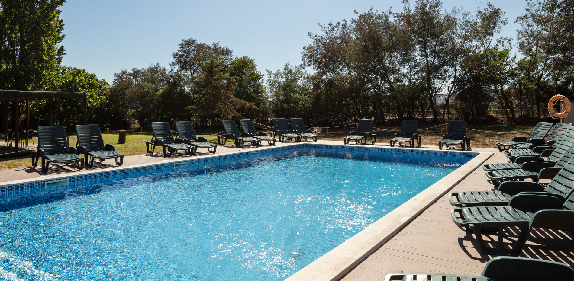 a large swimming pool surrounded by chairs and trees
