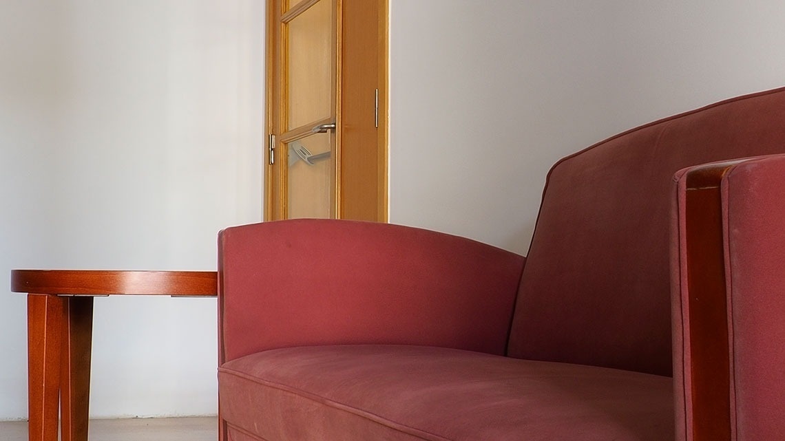 Sofá vermelho e mesa de madeira no Flag Hotel Porto-Maia. Visite nosso site oficial!
