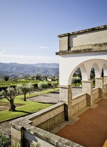 uma varanda com vista para um campo de grama e montanhas